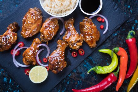 Spicy asian style glazed chicken wings with rice and soy sauceの写真素材