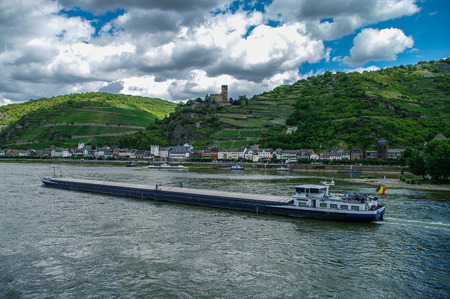 Cargo ship on Rhine river. Germany. Romantic Gutenfels medieval castle, hills with the famous vineyards of the Rhine and medieval village on background.のeditorial素材