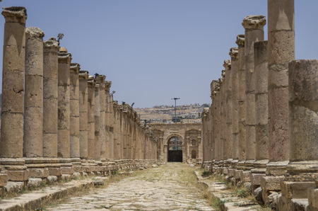 Columns in Colonnaded Street and North Gate at background, Ancient Roman city of Gerasa of Antiquity , modern Jerash, Jordanの写真素材