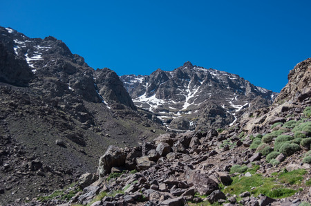 Toubkal national park in springtime with mount, cover by snow and ice, valley near Refuge Toubkal, start point for hike to Jebel Toubkal, â highest peak of Atlas mountains and Moroccoの写真素材