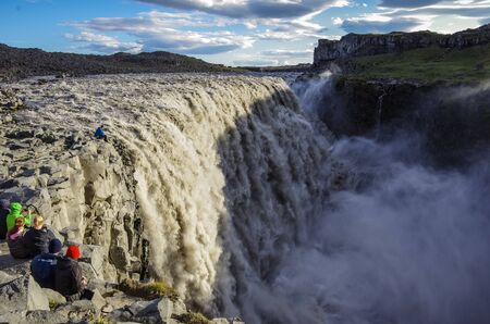 Tourist on the edg of Detifoss waterfall. One of the best attraction in Iceland. Dettifoss is the most powerful waterfall on Iceland and in the whole Europeの写真素材
