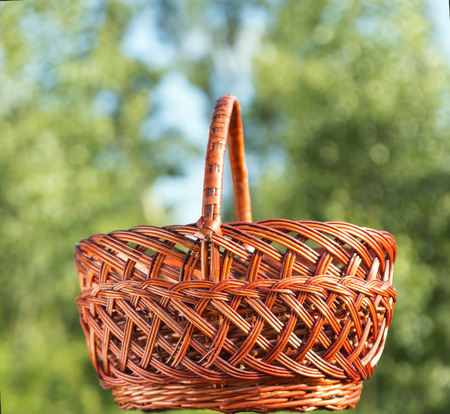 wicker basket on the background of trees and blue sky, sunlightの写真素材
