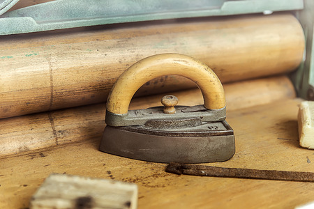 Old iron with the wooden handle iron surrounded by retro itemsの写真素材