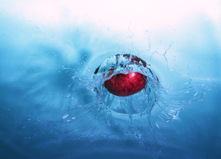 red ripe apple under blue with cold waterの写真素材