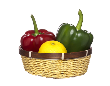 Green, red paprika and lemon in basket, isolated on white backgroundの写真素材