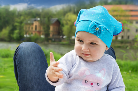 Little cute baby playing on the green flowering meadowの写真素材