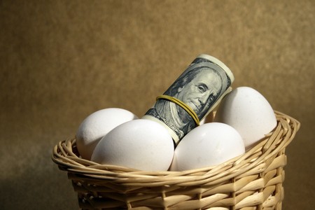 roll of dollars in the basket with eggsの写真素材