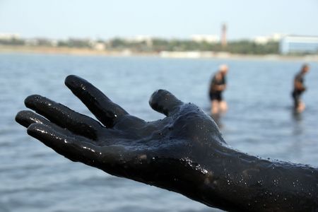 dirty  hand covered with mud on background of the salty lake, the town of Saki, Crimea, Ukraineの写真素材