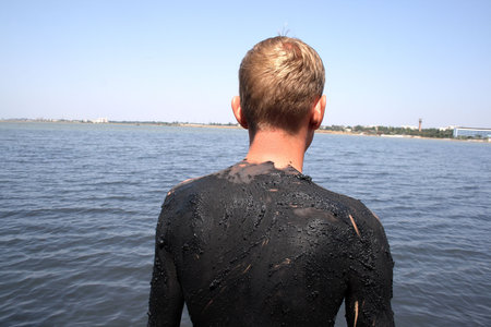 spin of a  young man covered with mud in the salty lake, the town of Saki, Crimea, Ukraine