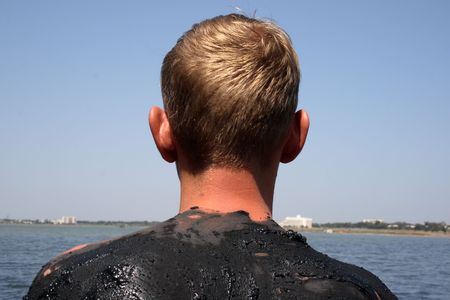 spin of a  young man covered with mud in the salty lake, the town of Saki, Crimea, Ukraineの写真素材