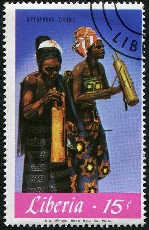 LIBERIA - CIRCA 1970s: A stamp printed in Liberia shows Womans playing on Xylophone Drums, circa 1970sの写真素材