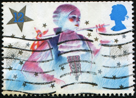 UNITED KINGDOM - CIRCA 1985: A stamp (Scott 2008 1124) printed in the United Kingdom shows image of the principal girl  in a Christmas pantomime, circa 1985 の写真素材
