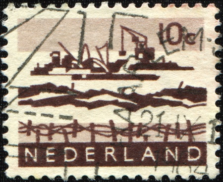 NETHERLANDS - CIRCA 1914: A stamp printed in the Netherlands shows construction of a dam in the North Sea, circa 1914 の写真素材