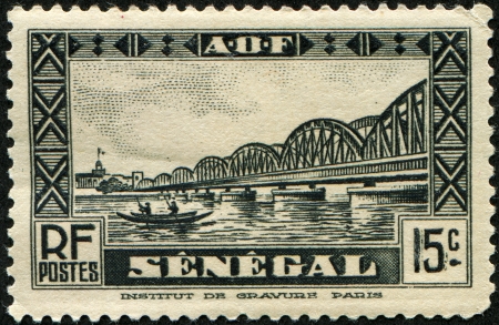 SENEGAL - CIRCA 1935: A stamp printed in Senegal shows railway bridge by Louis Faidherbe  across the river Saint-Louis, circa 1935の写真素材