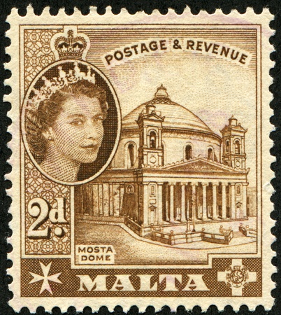 MALTA - CIRCA 1956: A stamp printed in Malta shows Queen Elizabeth II and Mosta Dome, circa 1956のeditorial素材