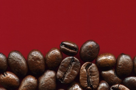 Roasted coffee beans on red  background の写真素材