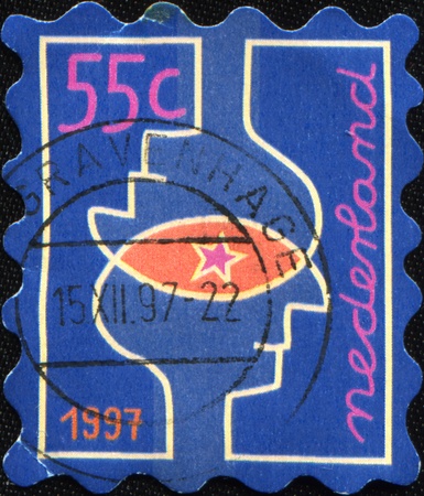 NETHERLAND - CIRCA 1997: A Christmas Stamps printed in Netherland Overlapping heads, circa 1997の写真素材