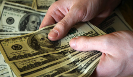 hand of man, who considers the money