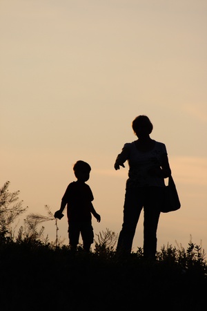 boy and woman against sunset sky の写真素材