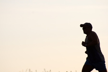 silhouette of running man on the background of sunset skyの写真素材