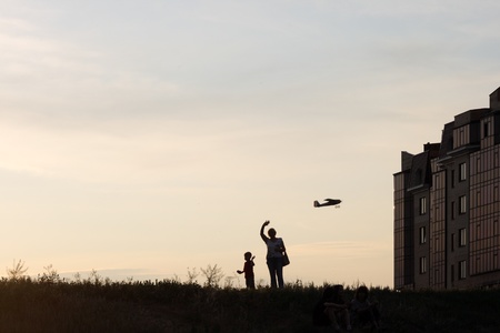 boy, woman and plane model against sunset sky の写真素材
