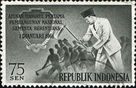 INDONESIA - CIRCAA 1961: A stamp printed in Indonesia honoring 	National Development Plan, shows President Sukarno and Workers Hoeing, circa 1961のeditorial素材