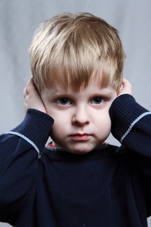 boy puts his hand over his earsの写真素材