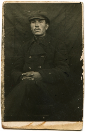 USSR - CIRCA 1925  Portrait of a seated man in a coat and cap, circa 1925のeditorial素材