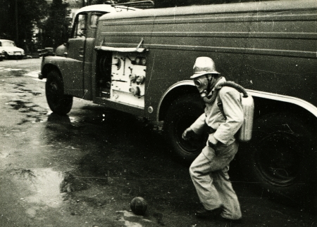 USSR - CIRCA 1984  Firefighter in the ovenproof jumpsuit and mask plays football against a fire truck, Voroshilovgrad , now Lugansk, Ukraine, circa 1984のeditorial素材