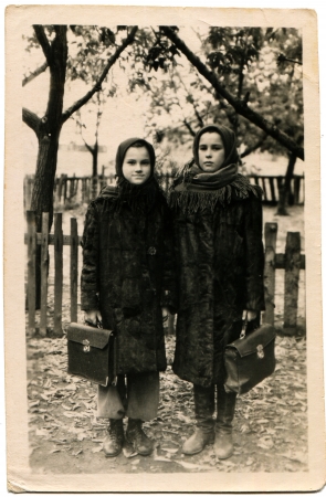 USSR - CIRCA 1930s  Two girls schoolgirl with briefcases in their hands are against the fence, circa 1930sのeditorial素材