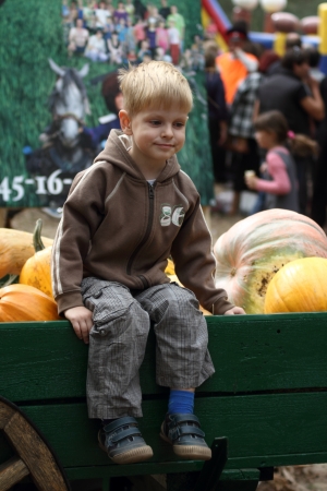 STANITSA LUGANSKAYA, UKRAINE - SEPTEMBER, 8, 2012  boy seating on car with pumpkins, International Cossack festival, Stanitsa Luganskaya, Ukraine, September 8, 2012のeditorial素材