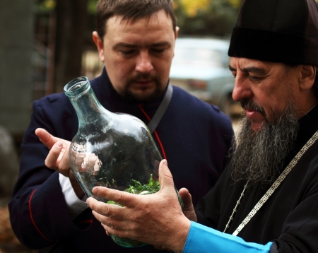  LUGANSK - OCT 14  Don Cossack  tells Orthodox priest about ancient cooking utensil vodka infusions, celebration of the Protection of the Mother of God, Lugansk, Ukraine, October 14, 2012 のeditorial素材