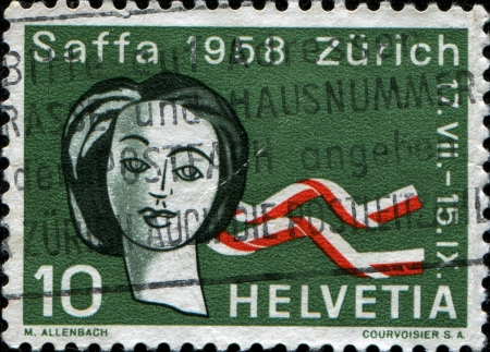 SWITZERLAND - CIRCA 1958: A stamp printed in Switzerland issued for Saffa Exhibition, Zurich shows  Woman's head with ribbons, circa 1958のeditorial素材