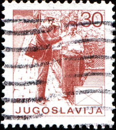 YUGOSLAVIA - CIRCA 1986  Stamp printed in Yugoslavia shows  Postman giving letters to man, circa 1986 のeditorial素材
