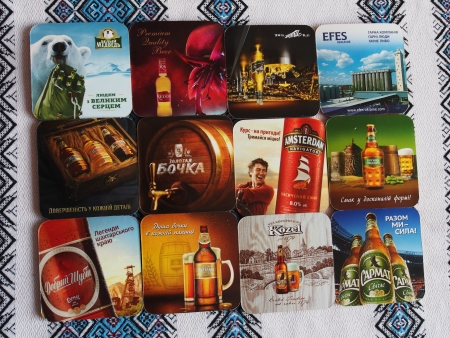 UKRAINE, LUGANSK - JANUARY 26, 2014: Modern beer mats.Beer lovers club meets monthly symbols in various pubs town. Men bring to meetings beer mats, labels and stoppers. They tasts new beers, discuss them and changing souvenirs.のeditorial素材