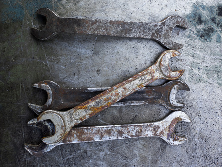Old rusty wrench on metal backgroundの写真素材