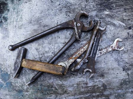 Old rusty wrench, hummer and nippers on metal backgroundの写真素材