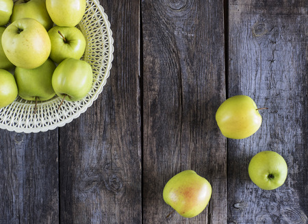 Overhead view of fresh green apples in plastic bowl placed on rustic wooden boards

の写真素材