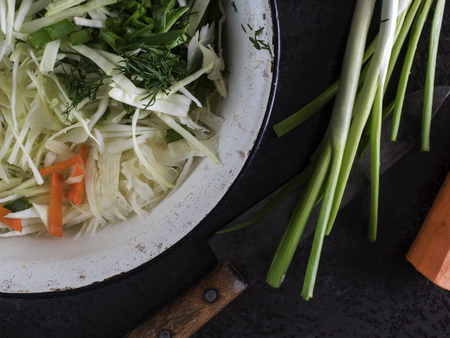 Top view of slaw, carrots and green onions on the stone tableの写真素材