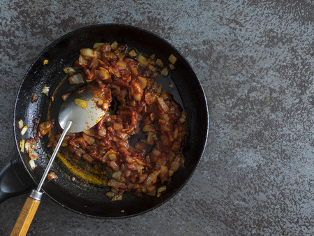 Top view of Stewed carrot and onion on pan on a black stone tableの写真素材