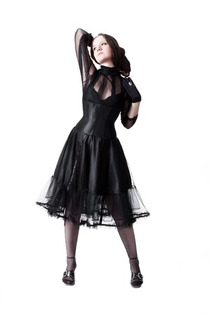 Gothic girl in black dress posing over white background の写真素材