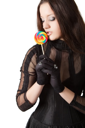 Gothic girl in black dress with lollipop. Isolated over white.の写真素材