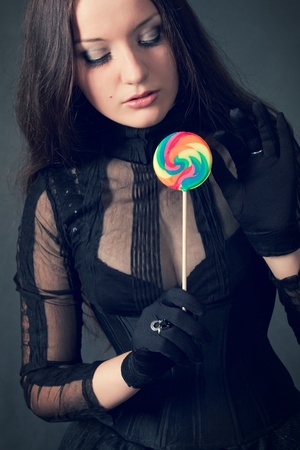 Gothic girl with lollipop over gray backgroundの写真素材