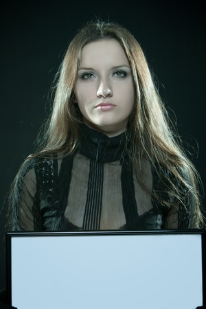 Pretty gothic girl with blank frame over darkの写真素材