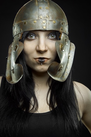 Pretty sexy girl with ancient roman helmet posing over dark background.の写真素材