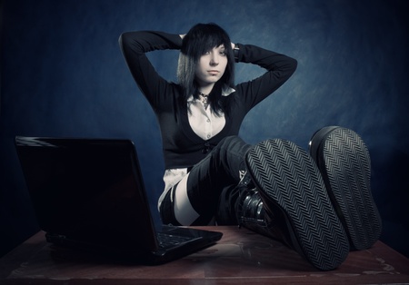 Pretty gothic girl with notebook posing over darkの写真素材