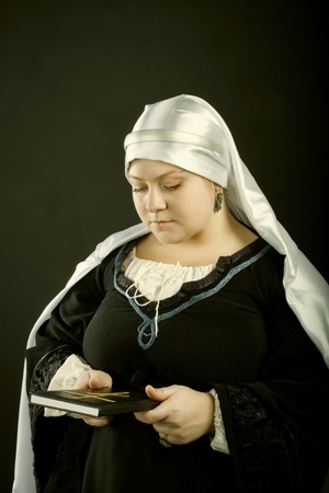 Medieval european woman posing over dark background. XV century.の写真素材