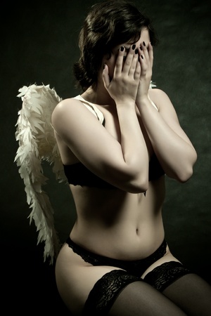 pretty angel in underwear posing over dark backgroundの写真素材