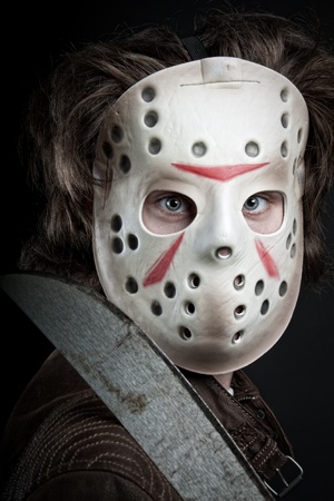 maniac in mask and machete in his hand posing over dark backgroundの写真素材