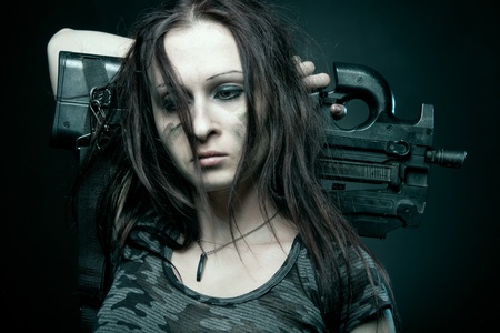 Woman soldier with fn p90 posing over dark backgroundの写真素材